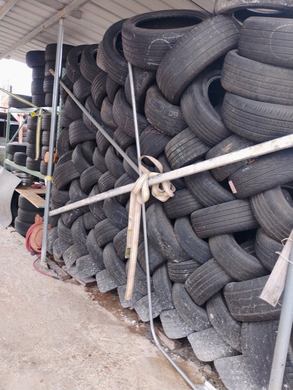 A large wall of tires stacked and stored at the shop
